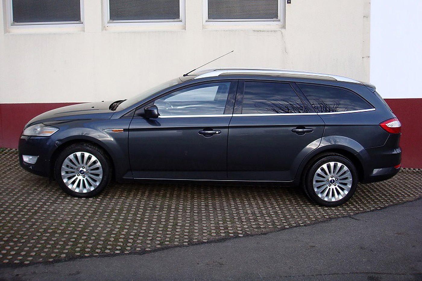 Ford Mondeo break gris foncé de profil, barres de toit